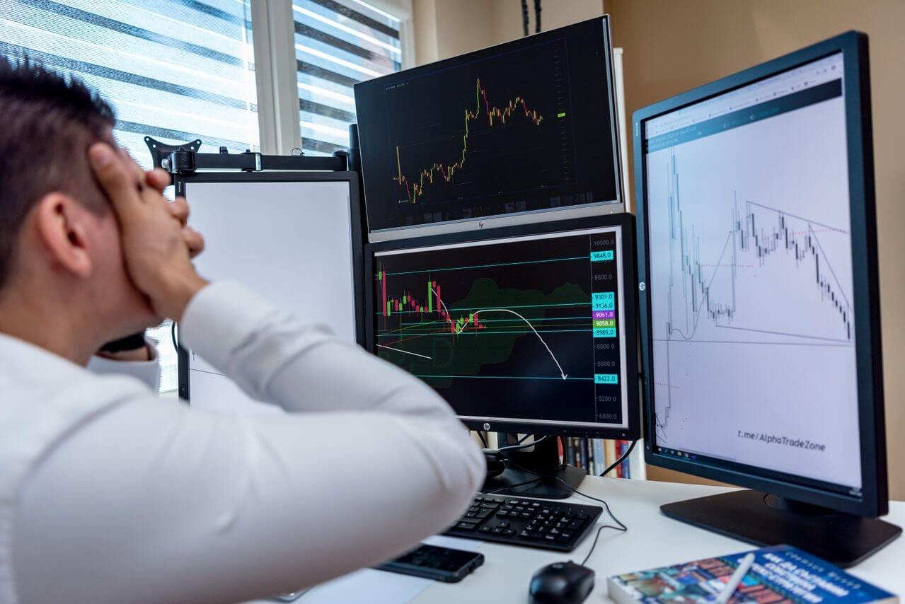 Stressed man watching stock market charts