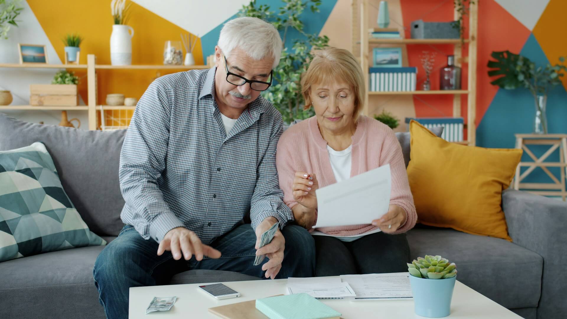 Elderly couple reviewing their finances before forming a gold retirement investing plan