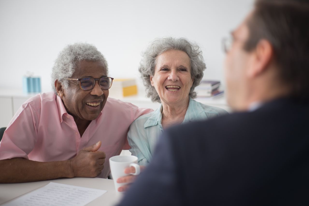Elderly couple talking with an expert about the best type of IRA to open for retirement