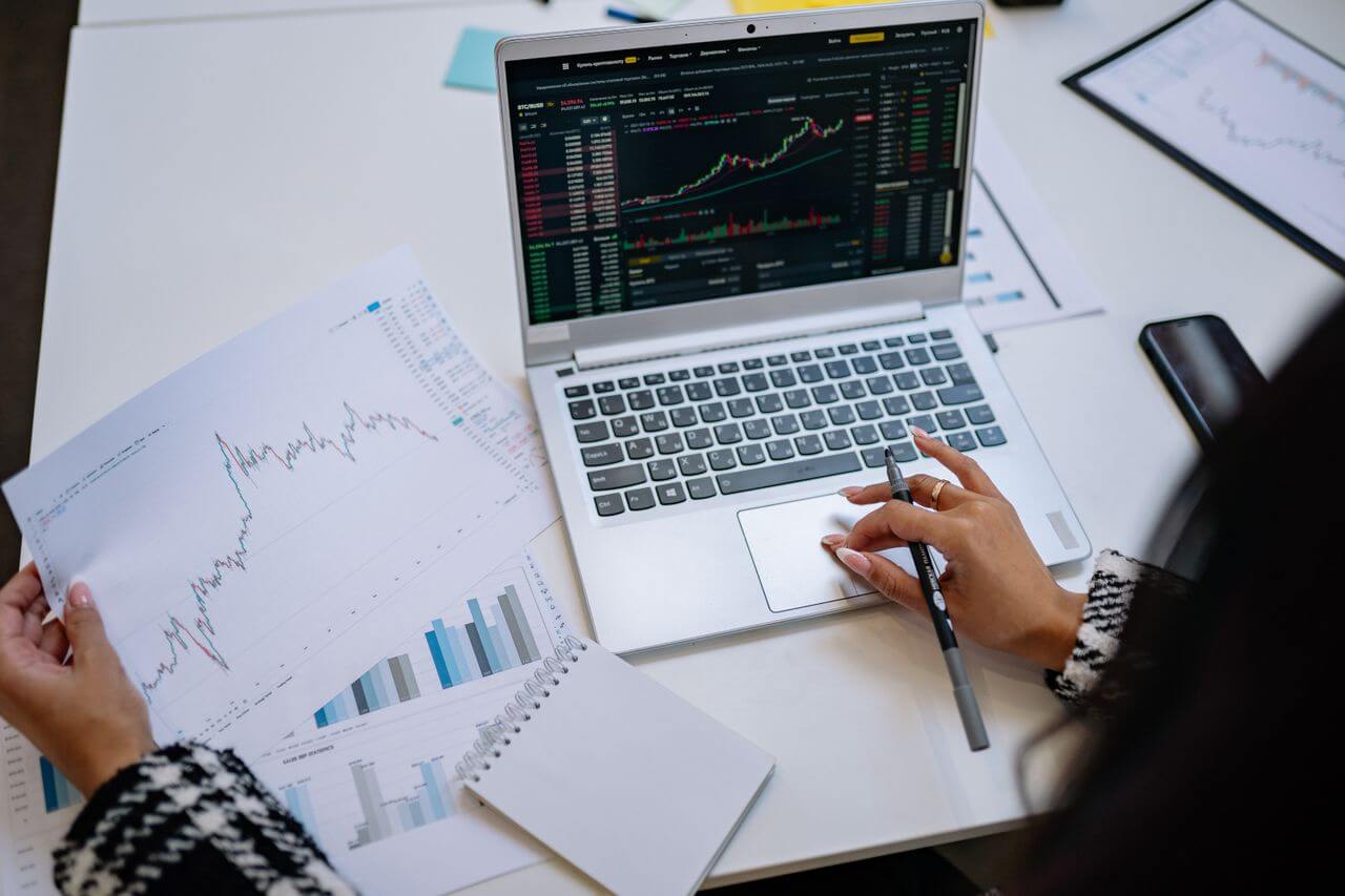 Person analyzing financial charts to determine the best gold IRA investment amount