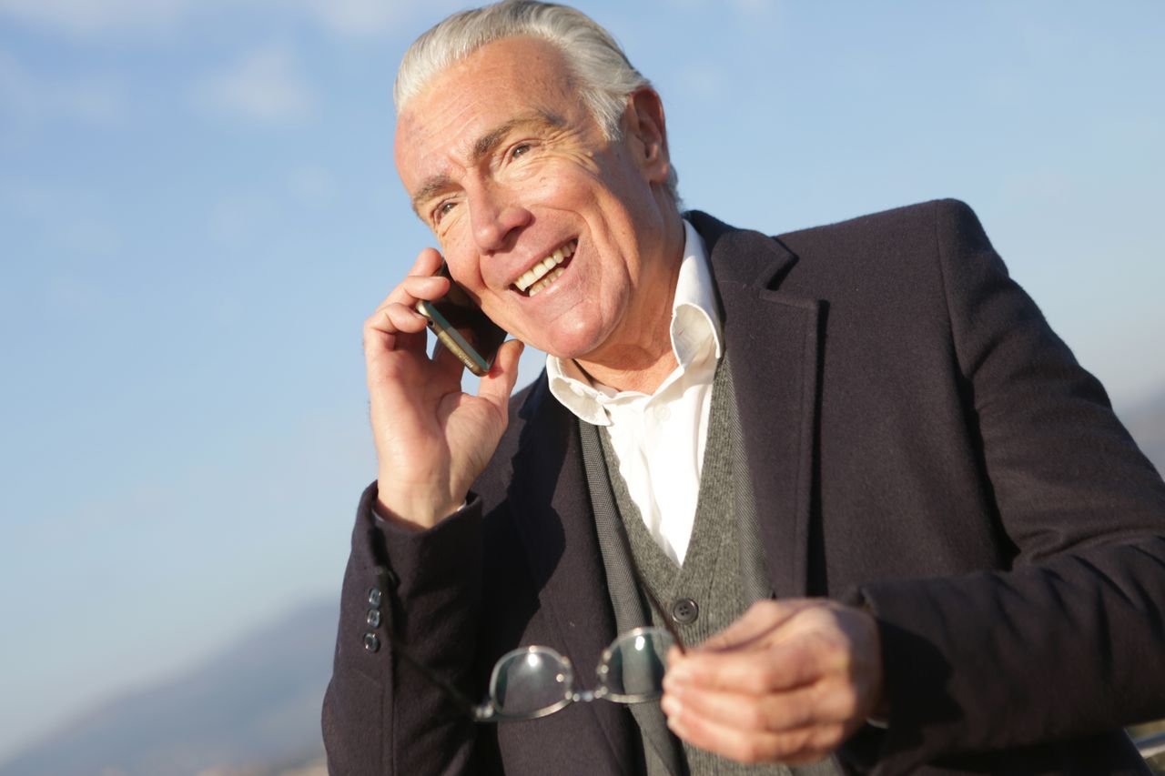 Elderly man on phone talking to precious metals specialist about his gold IRA retirement plan