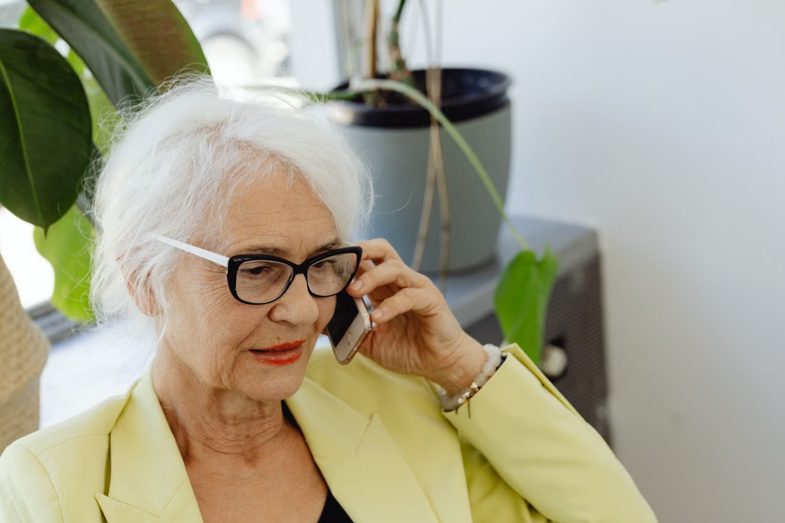 Elderly woman talking on the phone about achieving financial confidence with gold 