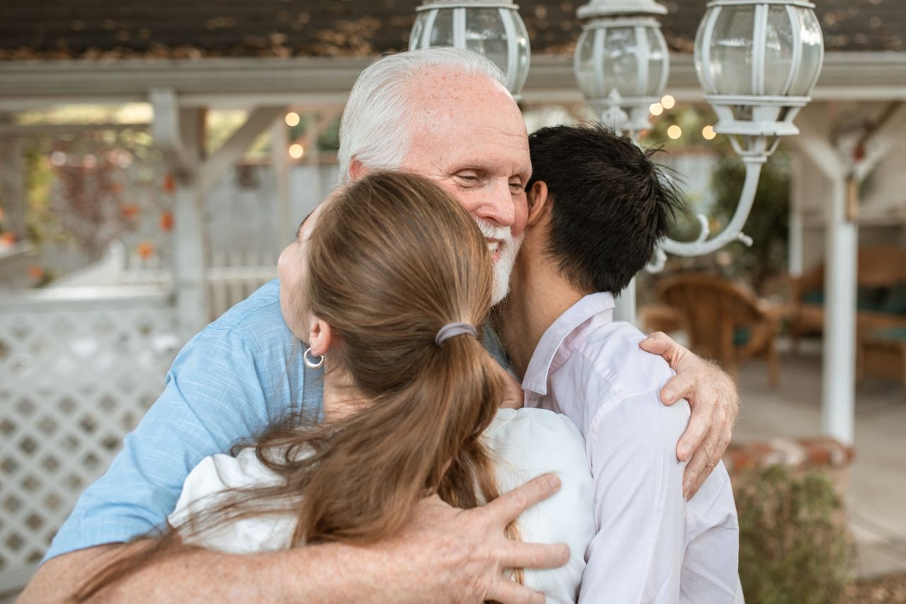 elderly man hugging loved ones who will receive his gold inheritance