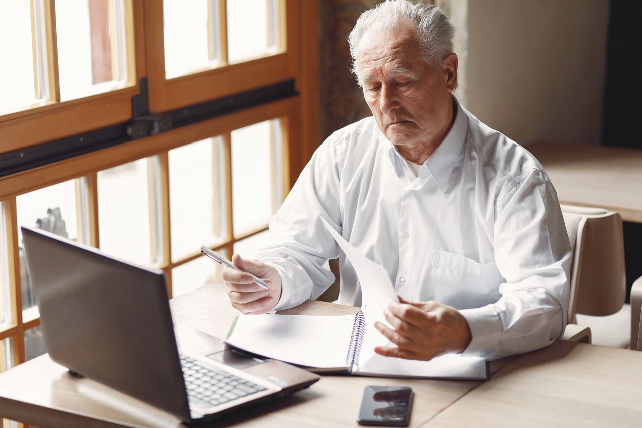 Elderly man reviewing his finances and considering investing for stagflation
