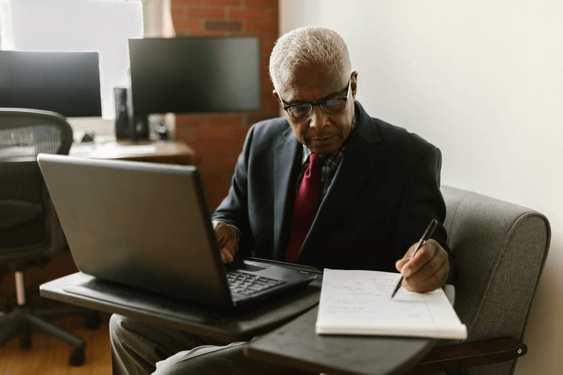Elderly man using a laptop to gain a better understanding of investments