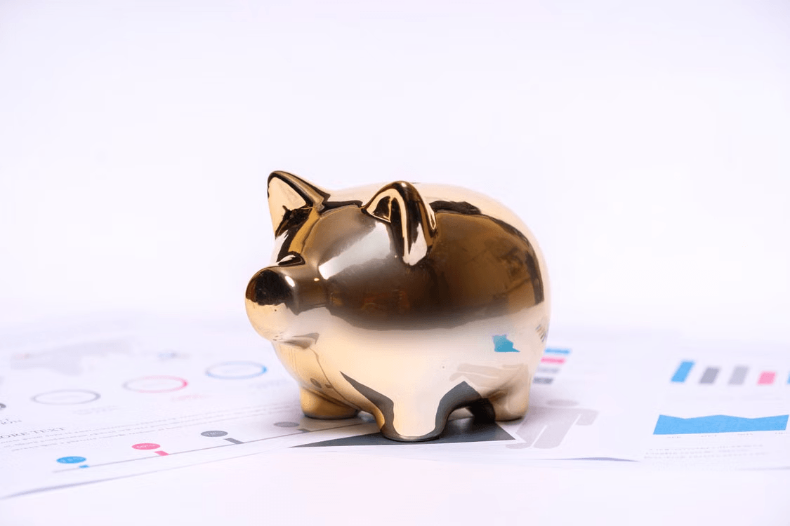 Gold piggy bank on financial charts