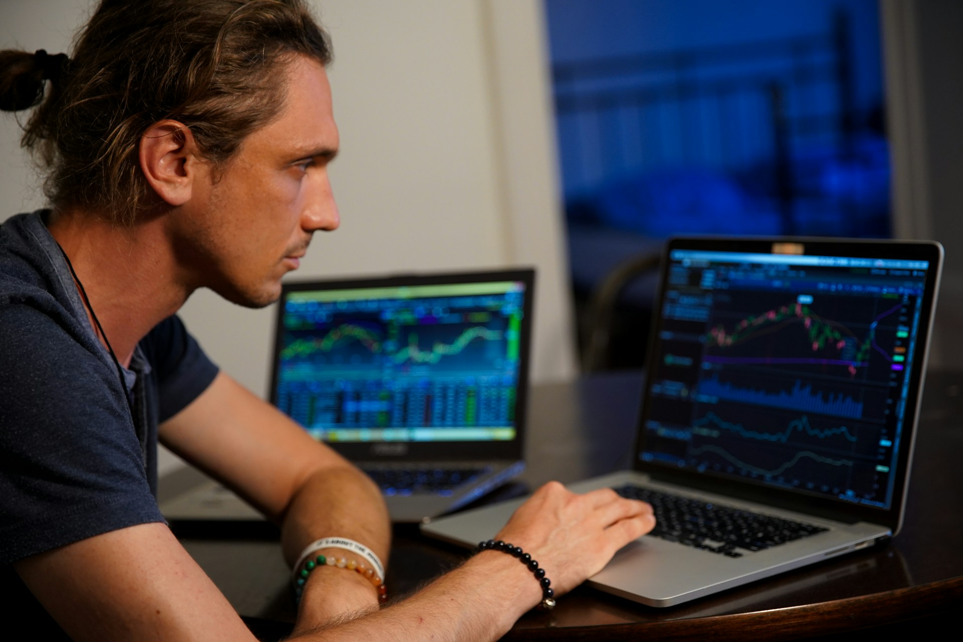 Man analyzing long-term investing charts on two laptops