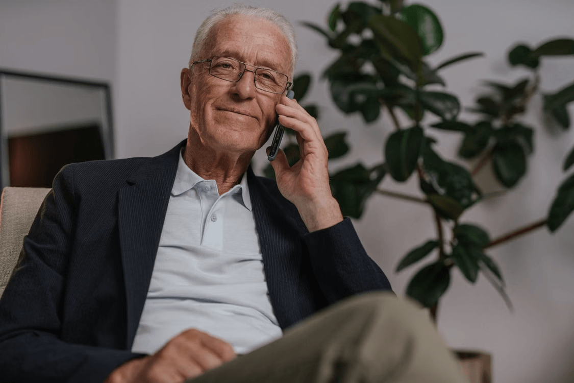 Elderly man on a phone consultation about stable investments
