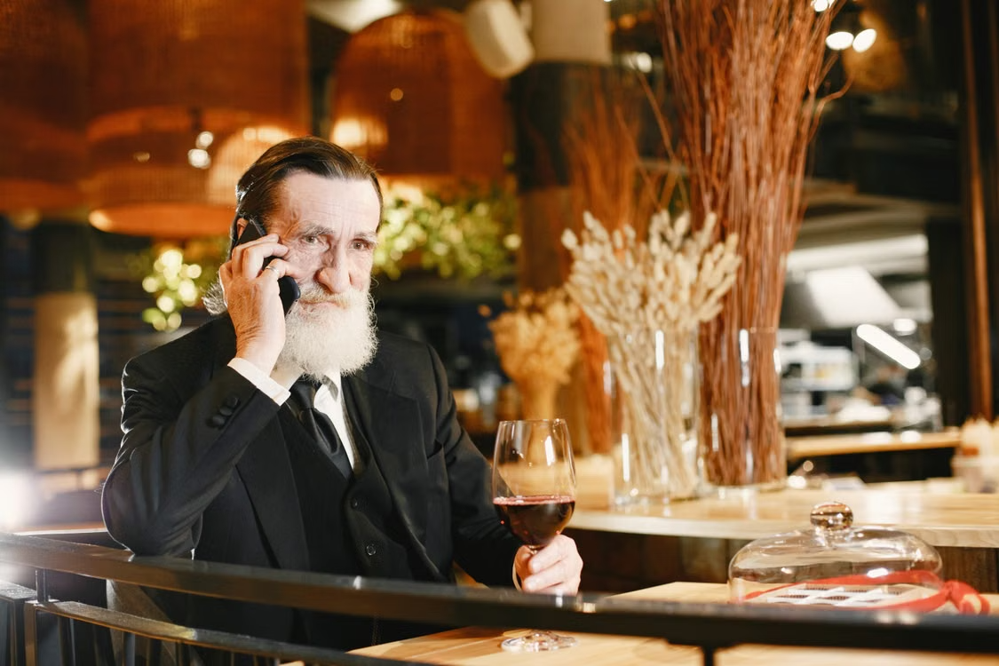 Elderly man on the phone discussing how to achieve financial security with gold 