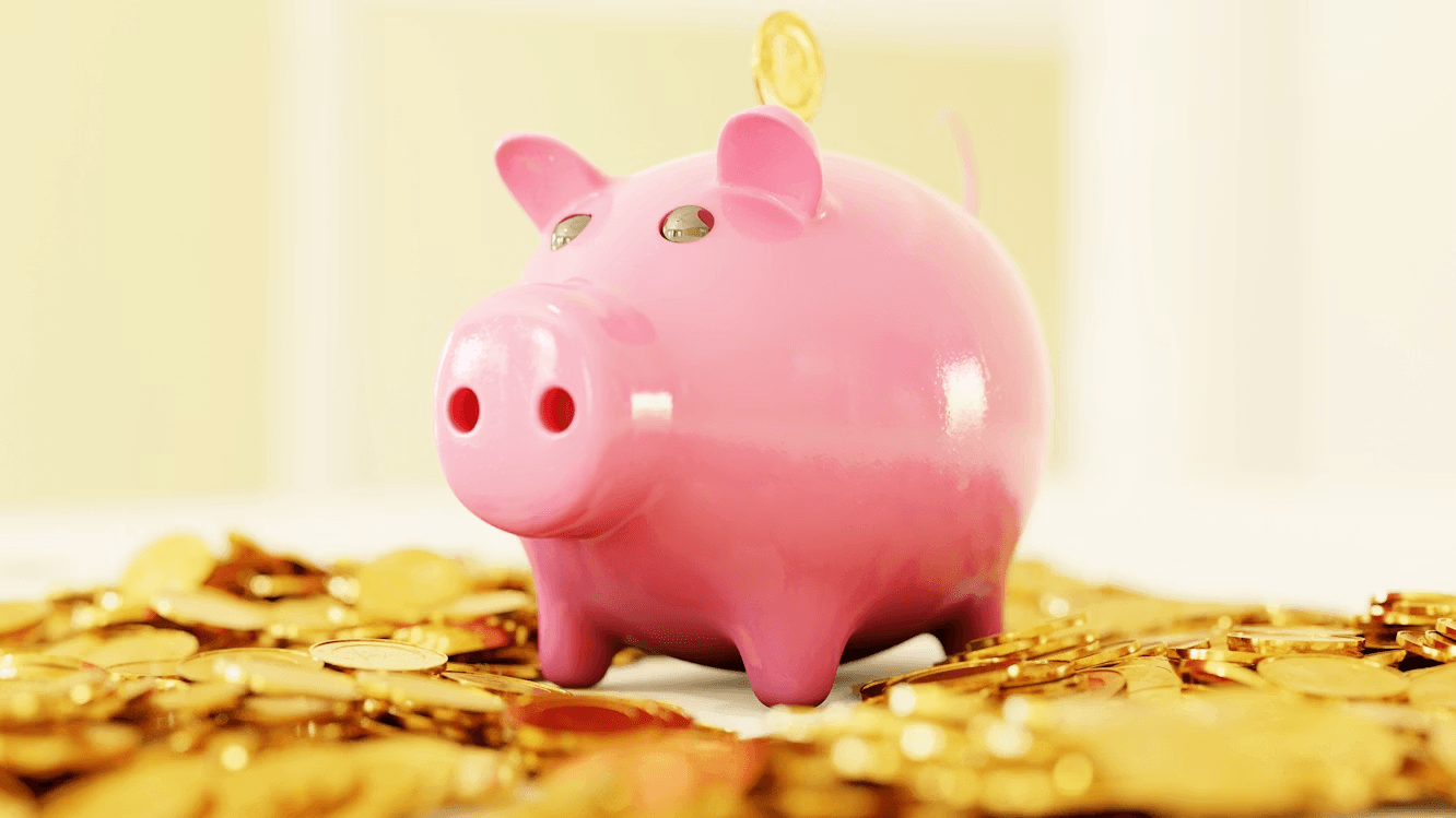 A piggy bank surrounded by gold coins, one of the most popular tangible asset investments