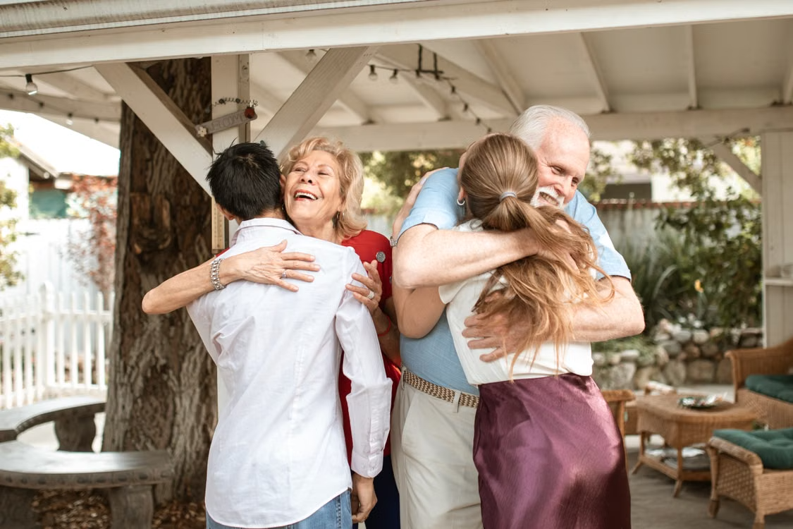 Elderly couple hugging children